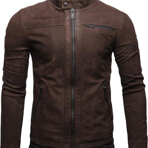May include: A dark brown jacket with a matte finish, featuring a stand-up collar with a snap button closure, a central full-length zip, two slanted zipped pockets at the waist, and one horizontal zipped pocket on the upper left chest.