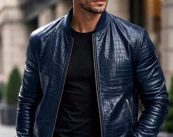 May include: A navy blue leather bomber jacket with a textured, crocodile-like pattern. The jacket features a zip closure, ribbed cuffs, and a matching ribbed collar. The person is wearing a black t-shirt and sunglasses.
