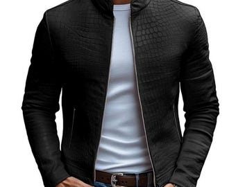 May include: A black jacket with a textured crocodile skin pattern, featuring a stand-up collar and a full-length silver zip down the centre. The jacket is worn over a plain white t-shirt, paired with blue denim jeans and a brown leather belt.
