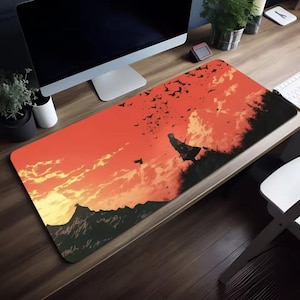 May include: A rectangular mouse pad featuring a sunset scene with a silhouette of a figure on a hill, and a flock of birds. The color palette includes shades of orange, red, and black. The mouse pad is designed for computer use.