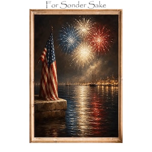 May include: A framed wall art print titled For Sonder Sake featuring a United States flag standing on a stone pier at night. Above the water, red, white, and blue fireworks illuminate the dark sky, with their reflections shimmering on the surface.