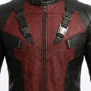 May include: A black and red leather jacket with a zip-up front and shoulder straps. The jacket features a distinctive design with black panels and red accents, and metal buckles.
