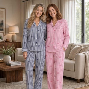 May include: Two sets of long-sleeved button-down pajamas with a notched collar and a chest pocket. One set features navy blue vertical stripes with small white bow patterns, while the other set features pink vertical stripes with small pink bow patterns.