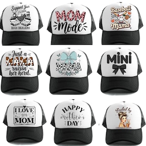 K&ouml;nnte beinhalten: Neun Trucker-Caps mit wei&szlig;en Fronten und schwarzen Mesh-R&uuml;cken. Die Caps zeigen verschiedene Designs und Texte, darunter "MOM MODE", "Baseball Mama" und "Happy Mother's Day". Die H&uuml;te sind eine Mischung aus Stilen und Themen.