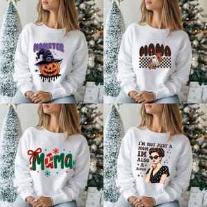 K&ouml;nnte beinhalten: Vier wei&szlig;e Sweatshirts mit verschiedenen Designs. Eines zeigt "Momster" mit einem K&uuml;rbis, ein anderes "Mama" mit einem Geist, ein drittes "Mama" mit Weihnachtsdekorationen und das letzte "I'm not just a Mom, I'm also a Bitch."