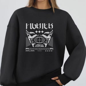 May include: Black sweatshirt with a white graphic design. The design features two stylized faces, a globe, and the words "URBAN CULTURE" in a bold font. Additional text is printed below the graphic.