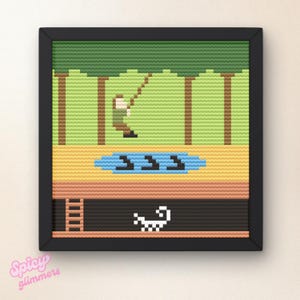 Op de afbeelding: Ingelijste pixelkunst die een visscène uitbeeldt. Het kunstwerk toont een gepixeleerde visser, een blauwe vijver met het nummer "333" en een zwart frame. Het kleurenpalet omvat groen, bruin, geel en zwart.