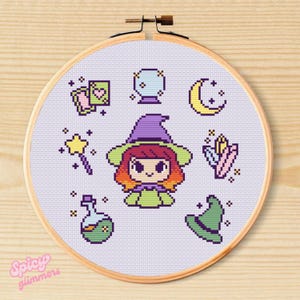 May include: A cross-stitch embroidery hoop featuring a cartoon witch with orange hair and a purple hat, surrounded by magical symbols. The design includes a crystal ball, potion bottle, and a crescent moon. The text "Spicy Glimmers" is at the bottom.