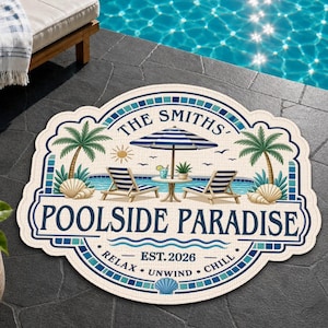 Puede incluir: Una alfombra decorativa redonda con un gráfico azul y blanco de dos tumbonas, una mesa y una sombrilla junto a una piscina. El texto dice THE SMITHS POOLSIDE PARADISE EST. 2026 RELAX UNWIND CHILL. El diseño incluye palmeras y conchas marinas.