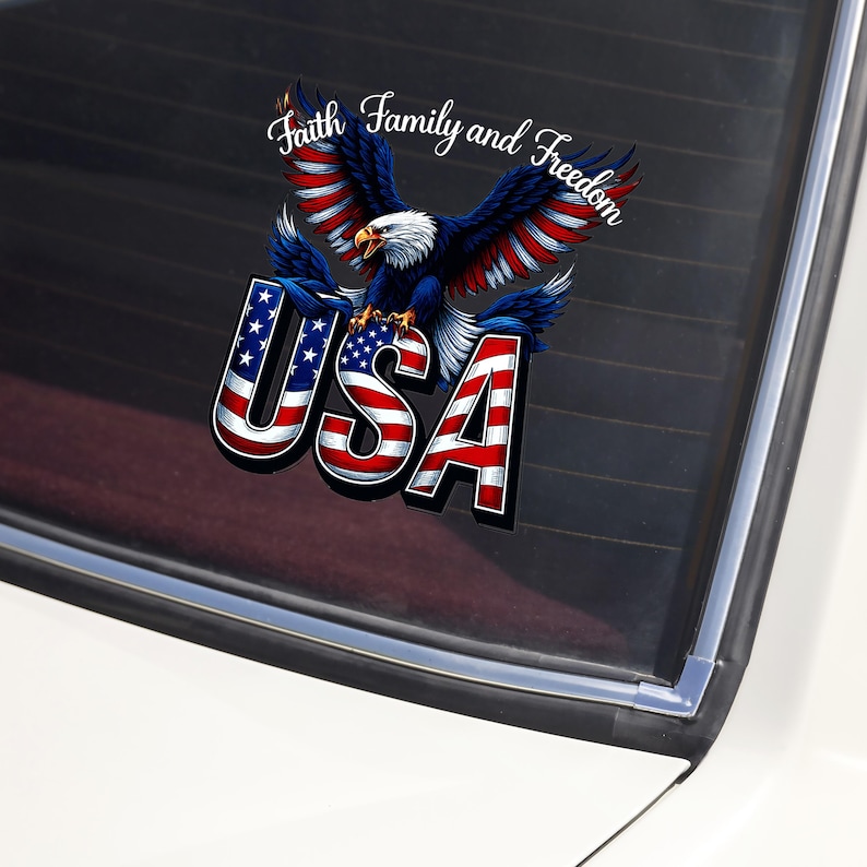 May include: A patriotic decal featuring a bald eagle with outstretched wings, colored in red, white, and blue. The word "USA" is prominently displayed below the eagle, with the text "Faith Family and Freedom" above.