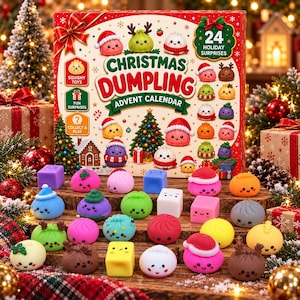 Op de afbeelding: Een Christmas Dumpling adventskalenderdoos met 24 vakjes, gepresenteerd met een assortiment kleurrijke, kleine, squishy speeltjes in de vorm van dumplings en blokjes met schattige gezichtjes op een houten ondergrond.