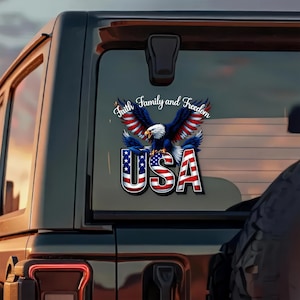May include: A patriotic decal featuring a bald eagle with outstretched wings, colored in red, white, and blue. The word "USA" is prominently displayed below the eagle, with the words "Faith, Family, and Freedom" above.
