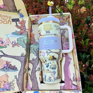 Op de afbeelding: Een witte keramische mok met een zwarte handgreep en de tekst "But First, Coffee" in een vetgedrukte, zwarte letter. De mok staat tegen een vage achtergrond. De mok is ongeveer 10 cm hoog.