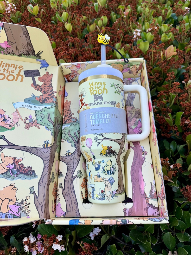 Op de afbeelding: Een witte keramische mok met een zwarte handgreep en de tekst "But First, Coffee" in een vetgedrukte, zwarte letter. De mok staat tegen een vage achtergrond. De mok is ongeveer 10 cm hoog.