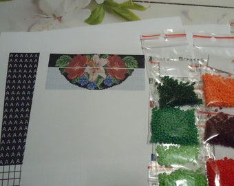 May include: A close-up of a beading kit with a printed pattern of flowers and leaves. The kit includes a variety of colored beads in small plastic bags labeled "Chart #" and "Chart #".