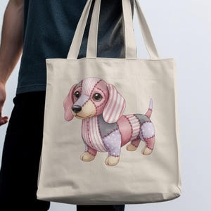 Può includere: Una borsa tote beige con un'illustrazione colorata di bassotto patchwork. Il cane ha toppe rosa, grigie e lavanda con motivi a righe e pois. La borsa ha manici lunghi color crema.