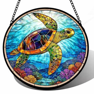 May include: A round stained glass window featuring a colorful sea turtle swimming in a vibrant blue ocean. The turtle has a multi-colored shell and is surrounded by coral and aquatic plants. The window is framed in black and hangs from a chain.