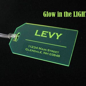 May include: A green luggage tag with the text "LEVY" and the address "11234 MAIN STREET GLENDALE, NH 03848".