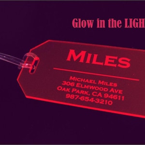 May include: Red luggage tag with the name "MILES" and contact information for Michael Miles, including address and phone number. The tag glows in the dark.