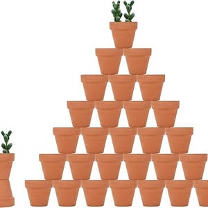 May include: A large collection of terracotta plant pots arranged in a pyramid shape, with one additional pot stacked upside down beneath another upright pot containing a small green succulent plant, all featuring a classic matte clay finish.