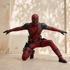 Può includere: Un costume integrale di Deadpool composto da una tuta rossa e nera testurizzata con maschera abbinata. L'outfit include una cintura multiuso con fibbia circolare, guanti neri, ginocchiere e cinghie tattiche sulle gambe con fondine.