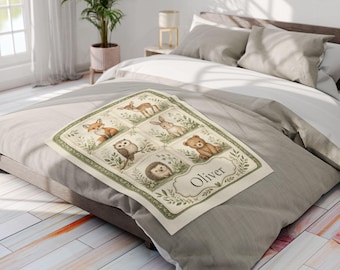 May include: A rectangular cream-colored blanket featuring a green border and a grid of illustrations depicting a deer, rabbit, fox, owl, hedgehog, and bear. The blanket includes a decorative label with the name Oliver printed in black text.
