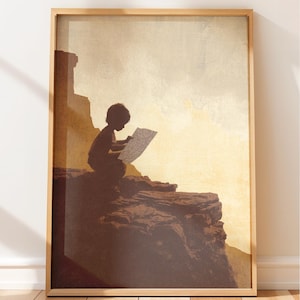 May include: A framed wall art print featuring a silhouette of a person sitting on a rocky cliff edge, looking at a map. The scene is rendered in warm shades of brown, tan, and cream, depicting a rugged landscape with a bright, hazy sky background.