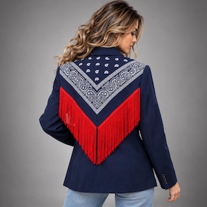 May include: A navy blue blazer featuring a large triangular back panel with a white paisley bandana print. The panel is bordered by long, vibrant red fringe that hangs down from the shoulders to the mid-back, creating a distinct layered look.