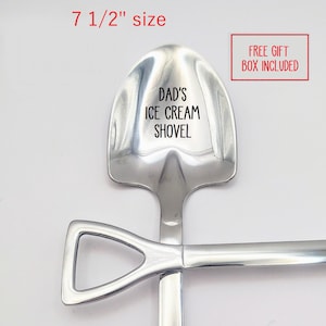 May include: A silver-colored metal spoon shaped like a shovel with a flat edge. The bowl of the spoon is engraved with the text DAD'S ICE CREAM SHOVEL. The handle features a triangular grip. The spoon measures 7 1/2 inches in total length.