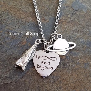 May include: Silver necklace with a heart charm that says "to infinity and beyond", a rocket charm, and a planet charm.