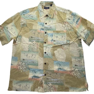 May include: A short-sleeved shirt with a tropical print. The beige shirt has a pattern of palm trees, leaves, and beach scenes in blue, pink, and green. The brand name "PLANK" is visible on the collar. The shirt has a button-down front.