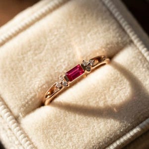 東西のバゲットカットルビーの婚約指輪、繊細なゴールドのプロミスリング、ミニマルな赤い宝石の重ね付けバンド、7月の誕生石のギフト（女性向け）。