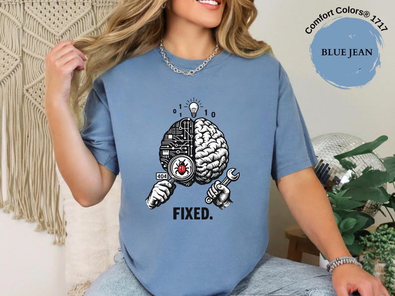 Shirt featuring a split brain with circuitry, a software bug, a 404 error icon, a wrench, and FIXED text in a developer debugging design.