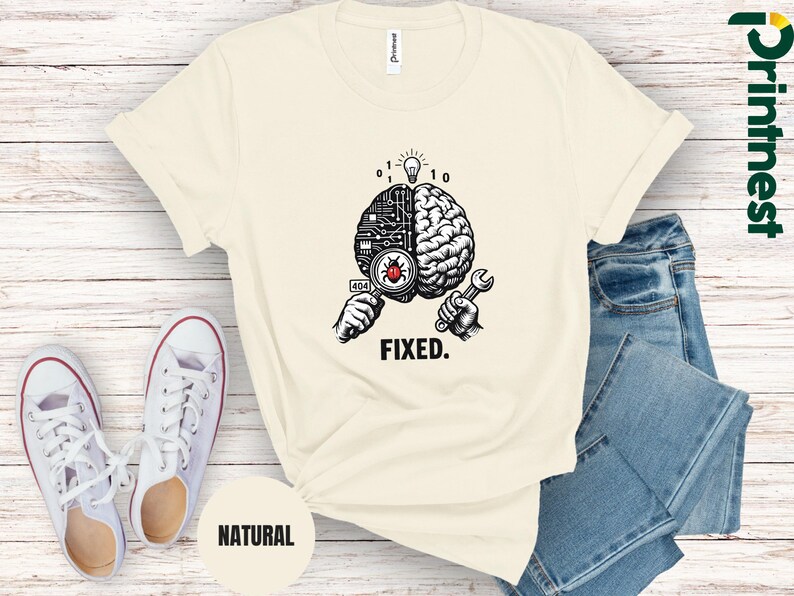 May include: A cream-colored t-shirt featuring a graphic of a brain split between a circuit board and organic tissue. One hand holds a magnifying glass over a red bug with a 404 label, while the other holds a wrench. The word FIXED is printed below.