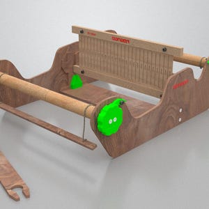May include: A wooden weaving loom with a rectangular frame, wooden dowels, and a separate wooden shuttle. The loom has green accents and the word "ozloom" in red. Ideal for textile crafts and weaving projects.
