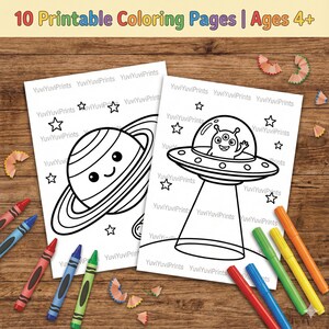 Op de afbeelding: Twee afdrukbare kleurplaten met illustraties van een planeet en een UFO met een alien. De tekst "10 Kleurplaten om af te drukken | Leeftijd 4+" staat bovenaan. Kleurpotloden en stiften liggen verspreid.