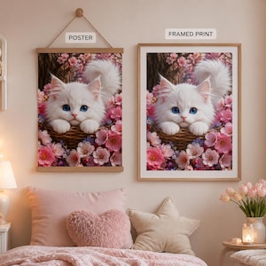 May include: A wall hanging poster and a framed print, both displaying an illustration of a fluffy white kitten with bright blue eyes sitting in a woven basket surrounded by pink cherry blossoms. The text POSTER and FRAMED PRINT are visible.