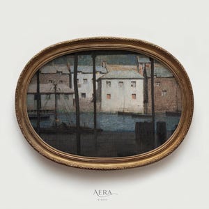 May include: An oval-shaped framed print of a harbor scene. The artwork depicts buildings and boats in muted tones of blue, brown, and white. The frame is gold-colored with an ornate design. The print is mounted on a white background.