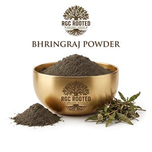 Könnte beinhalten: Eine goldfarbene Metallschale gefüllt mit dunkelgrauem Bhringraj-Pulver, daneben ein kleiner Haufen desselben Pulvers und getrocknete grüne Kräuter. Die Schale zeigt das Logo RGC Rooted Organic Goods, das auch über dem Text Bhringraj Powder steht.