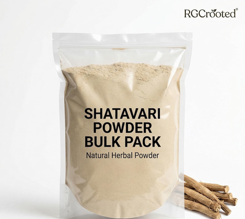 May include: A transparent plastic bag containing light brown Shatavari powder. The bag is labelled "SHATAVARI POWDER BULK PACK Natural Herbal Powder". Dried Shatavari roots are visible on the right.