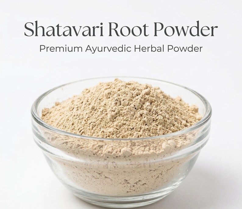 Może przedstawiać: Przezroczysta szklana miska wypełniona jasno brązowym proszkiem z korzenia Shatavari. Tekst nad miską brzmi "Shatavari Root Powder" i "Premium Ayurvedic Herbal Powder". Proszek ma drobną, ziarnistą konsystencję.