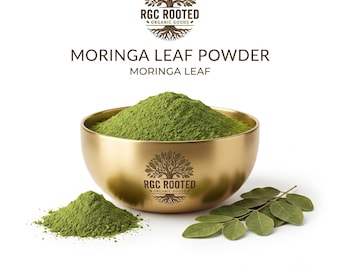 May include: A gold-toned bowl filled with vibrant green moringa leaf powder, featuring the RGC ROOTED ORGANIC GOODS logo. A small pile of the same green powder sits beside the bowl, accompanied by a fresh green moringa leaf sprig.