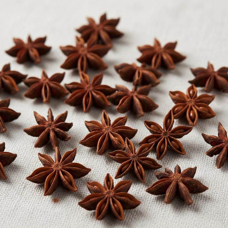 Whole star anise pods arranged together on a light surface, showing their natural dark brown color and star shape