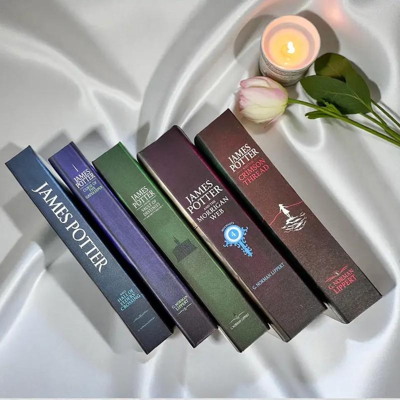 May include: A set of five James Potter books by G. Norman Lippert, including Hall of Elders Crossing, Curse of the Gatekeeper, Vault of Destinies, The Morrigan Web, and The Crimson Thread, arranged diagonally next to a lit candle and a pink tulip.