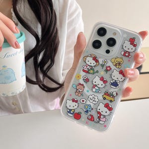 May include: Clear phone case featuring multiple Hello Kitty character designs with red bows and various accessories. The case has a glittery background and includes the text "It's for you."