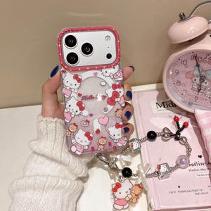 May include: A clear phone case with a pink trim, decorated with Hello Kitty characters and a matching charm bracelet. The case features a repeating pattern of the character with bows and teddy bears. The charm bracelet has black beads and Hello Kitty charms.