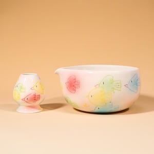 May include: A white ceramic mug with a black handle and the text "But First, Coffee" in a bold, black font. The mug is set against a plain white background, highlighting its simple design.