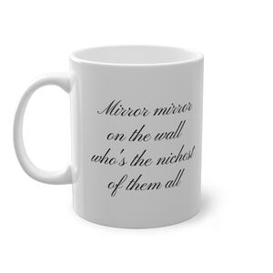 Peut inclure: Mug en céramique blanche avec une anse incurvée. Le mug présente le texte "Mirror mirror on the wall who's the richest of them all" en écriture noire. Le mug est conçu pour les boissons chaudes.