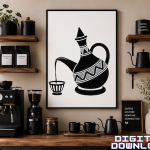May include: A framed wall art print featuring a black and white graphic illustration of a traditional coffee pot pouring liquid into a small cup. The design includes geometric patterns on the pot and is displayed in a black frame on a wall.