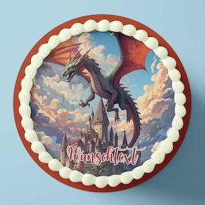 Puede incluir: Una tarta redonda con borde rojo y ribete de glaseado blanco. La tarta presenta una escena de fantasía con un dragón verde volando sobre un castillo, con el texto "Wunschtext" en escritura roja.